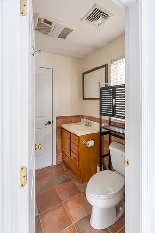 a bathroom with a toilet a sink and mirror