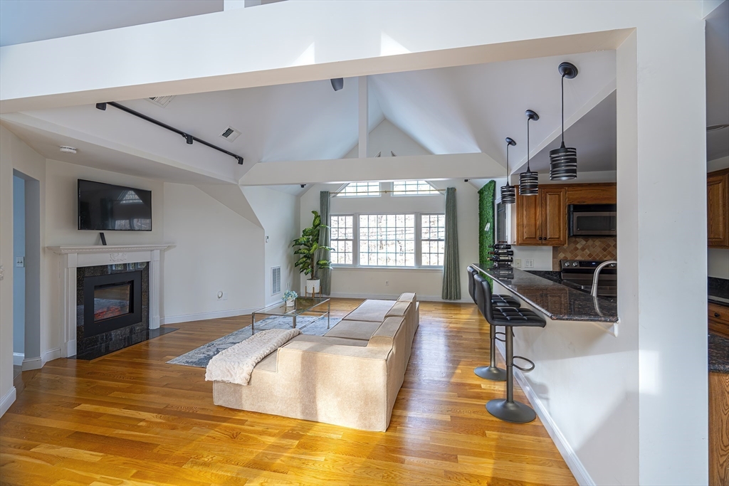 1364 High Street, Unit 1 Westwood, MA 02090 - Photo 2 of 16 a spacious bedroom with a bed and a flat screen tv