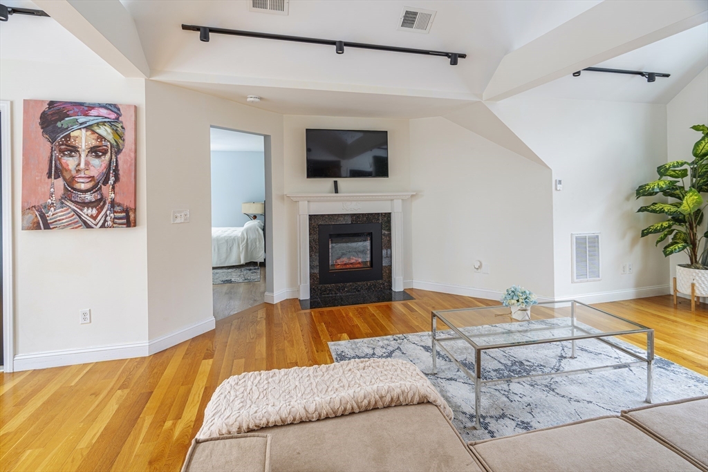 1364 High Street, Unit 1 Westwood, MA 02090 - Photo 3 of 16 a living room with a bed and a fireplace