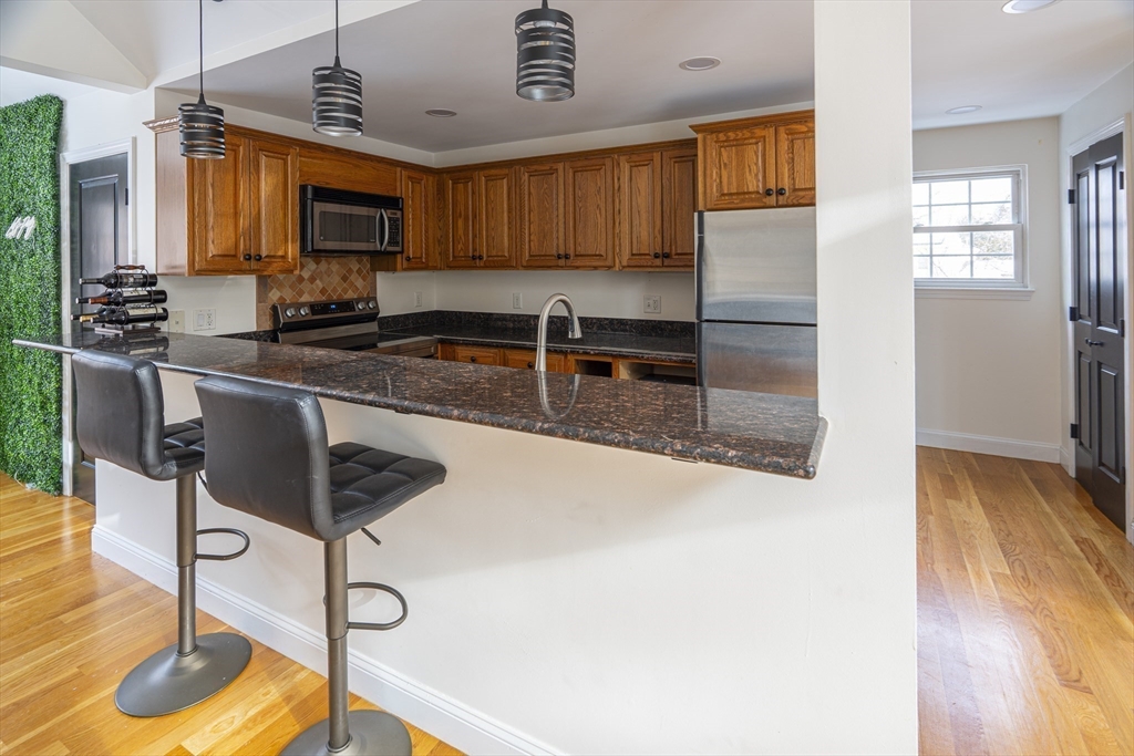 1364 High Street, Unit 1 Westwood, MA 02090 - Photo 6 of 16 a kitchen with stainless steel appliances granite countertop a sink a stove and a wooden floors