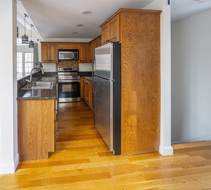1364 High Street, Unit 1 Westwood, MA 02090 - Photo 7 of 16 a kitchen with stainless steel appliances granite countertop a refrigerator a stove and a sink