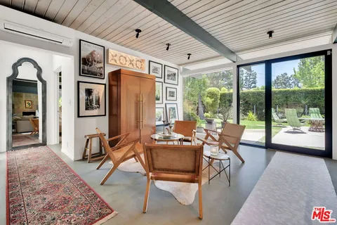 a living room with furniture and a floor to ceiling window