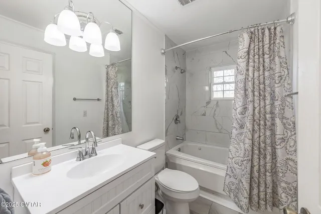 a bathroom with a sink a toilet a mirror a bathtub and shower