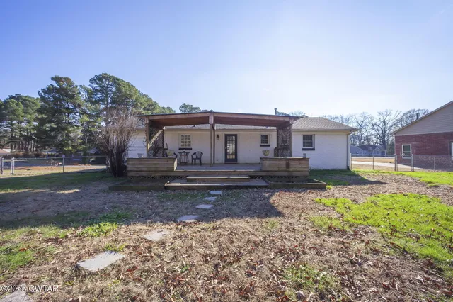 a view of a house with backyard and sitting area