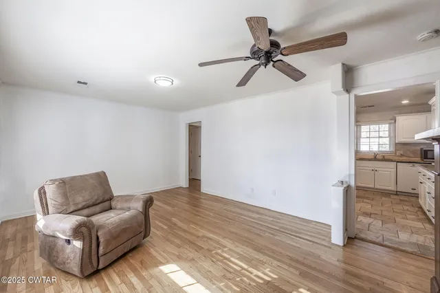 a living room with furniture and a ceiling fan
