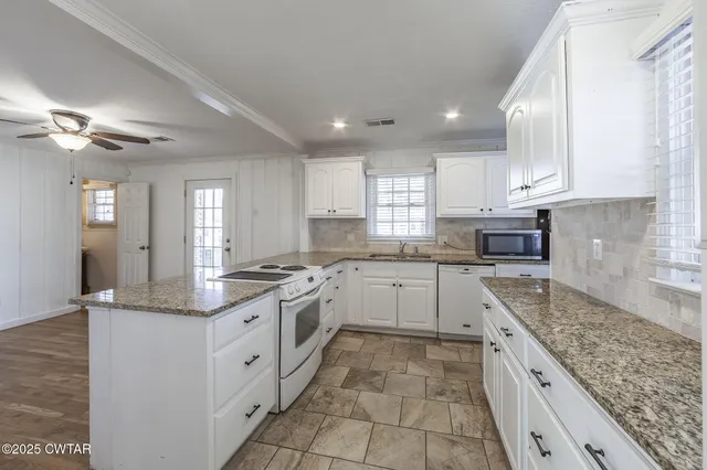 a kitchen with stainless steel appliances granite countertop a sink a stove and cabinets