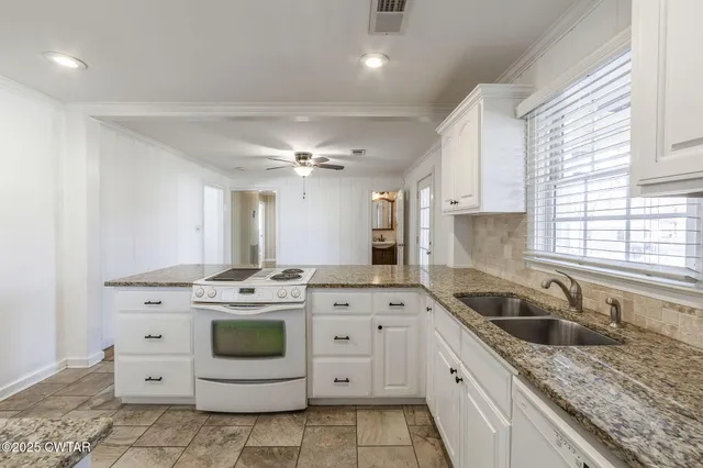 a kitchen with a stove sink and cabinets