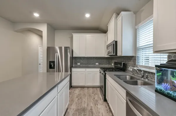 a kitchen with a sink a refrigerator and cabinets
