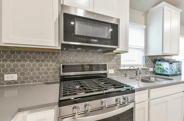 a stove top oven sitting inside of a kitchen