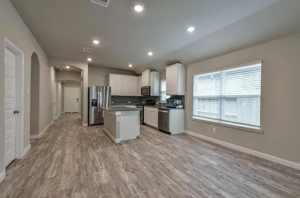 a large kitchen with cabinets and stainless steel appliances