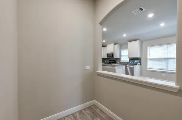 a view of a kitchen with a sink and dishwasher a refrigerator with wooden floor