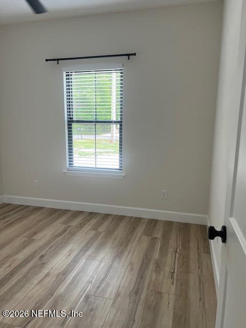 687 South Orange Street Starke, FL 32091 - Photo 4 of 13 an empty room with wooden floor and windows