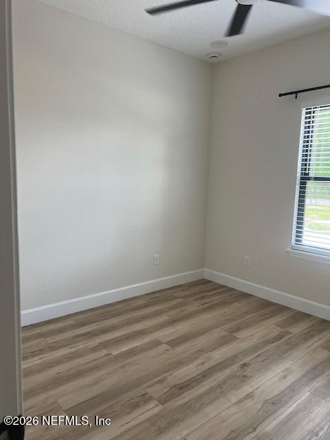 687 South Orange Street Starke, FL 32091 - Photo 5 of 13 an empty room with wooden floor and windows