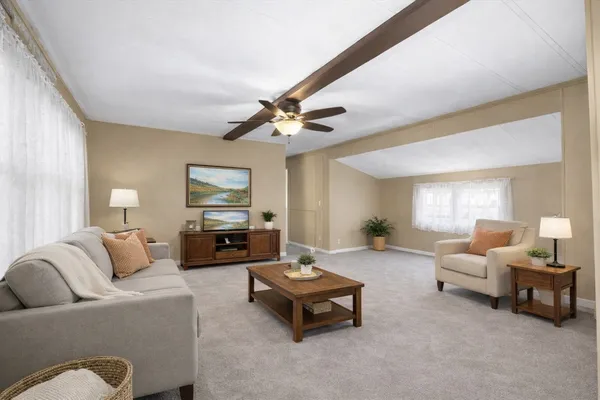 a living room with furniture and a ceiling fan