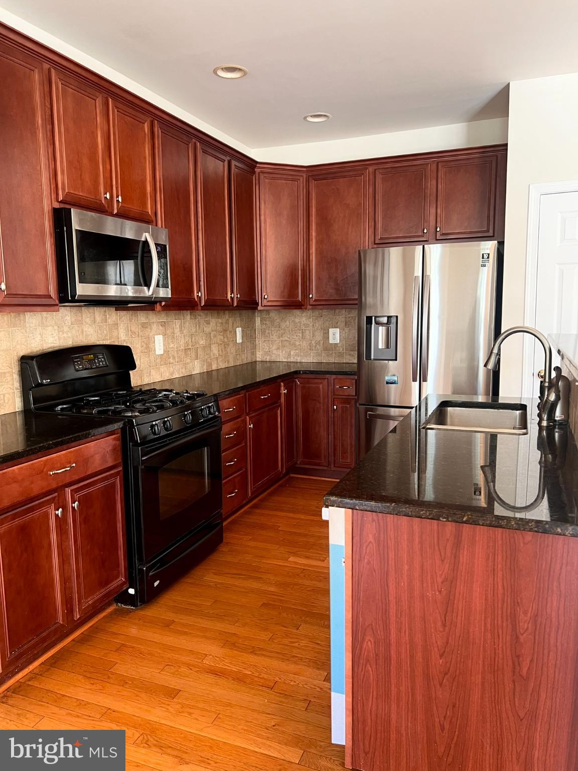 25205 Larks Terrace Chantilly, VA 20152 - Photo 4 of 28 Modern kitchen with rich wood cabinetry.