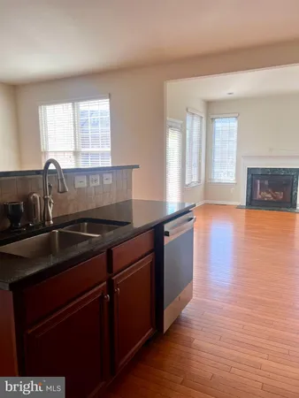 a kitchen with granite countertop a sink and wooden cabinets
