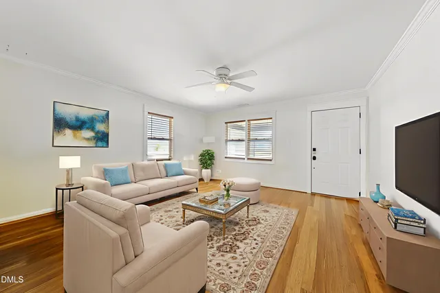 a living room with furniture a flat screen tv and a window