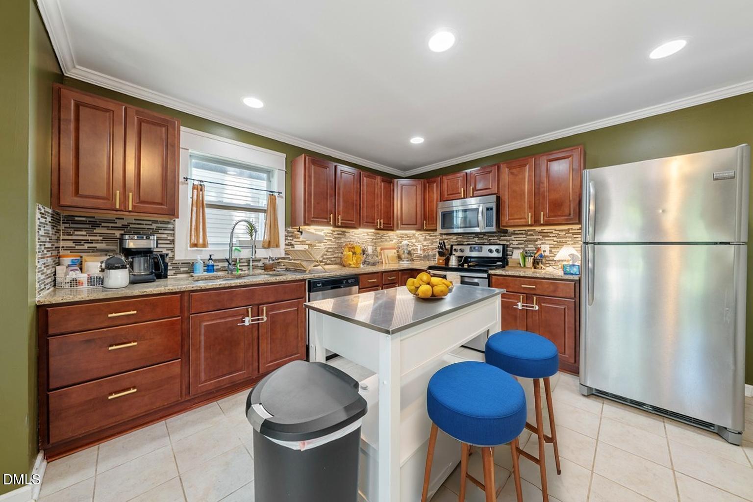 806 South Roxboro Street Durham, NC 27707 - Photo 6 of 25 a kitchen with granite countertop wooden cabinets a refrigerator a stove a sink and a center island