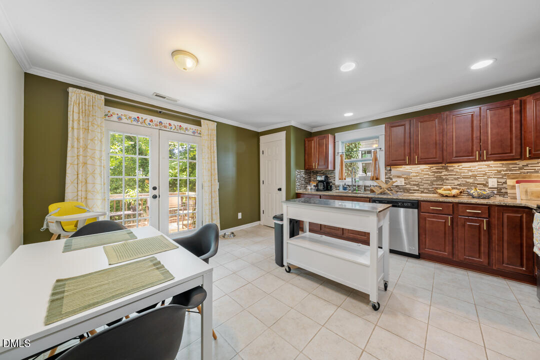 806 South Roxboro Street Durham, NC 27707 - Photo 7 of 25 a room with kitchen island granite countertop wooden cabinets a dining table and chairs
