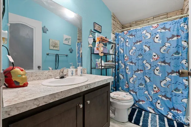 a bathroom with a sink a toilet and shower curtain