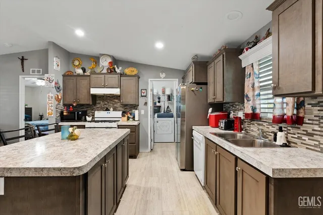 a kitchen with stainless steel appliances granite countertop a sink stove and refrigerator