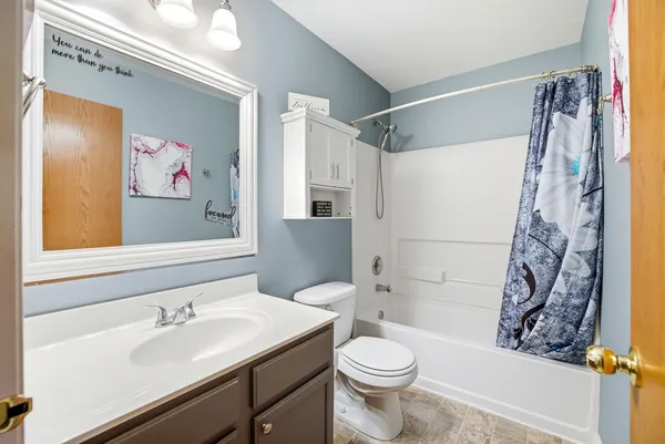 a bathroom with a sink a toilet and shower curtain