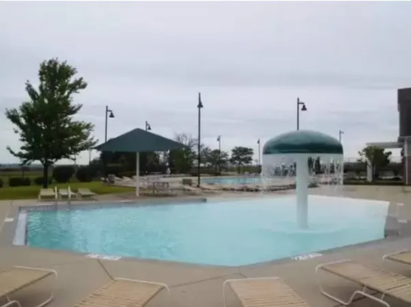 a view of a swimming pool with a table and chairs under an umbrella