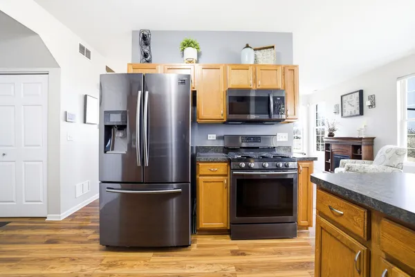 a kitchen with stainless steel appliances granite countertop a refrigerator stove and microwave