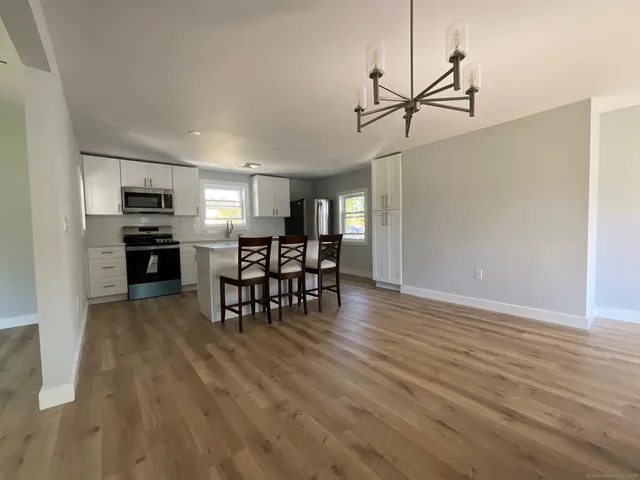 a view of a kitchen with dining room and wooden floor