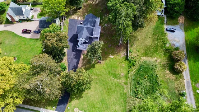 an aerial view of residential house with outdoor space and trees all around