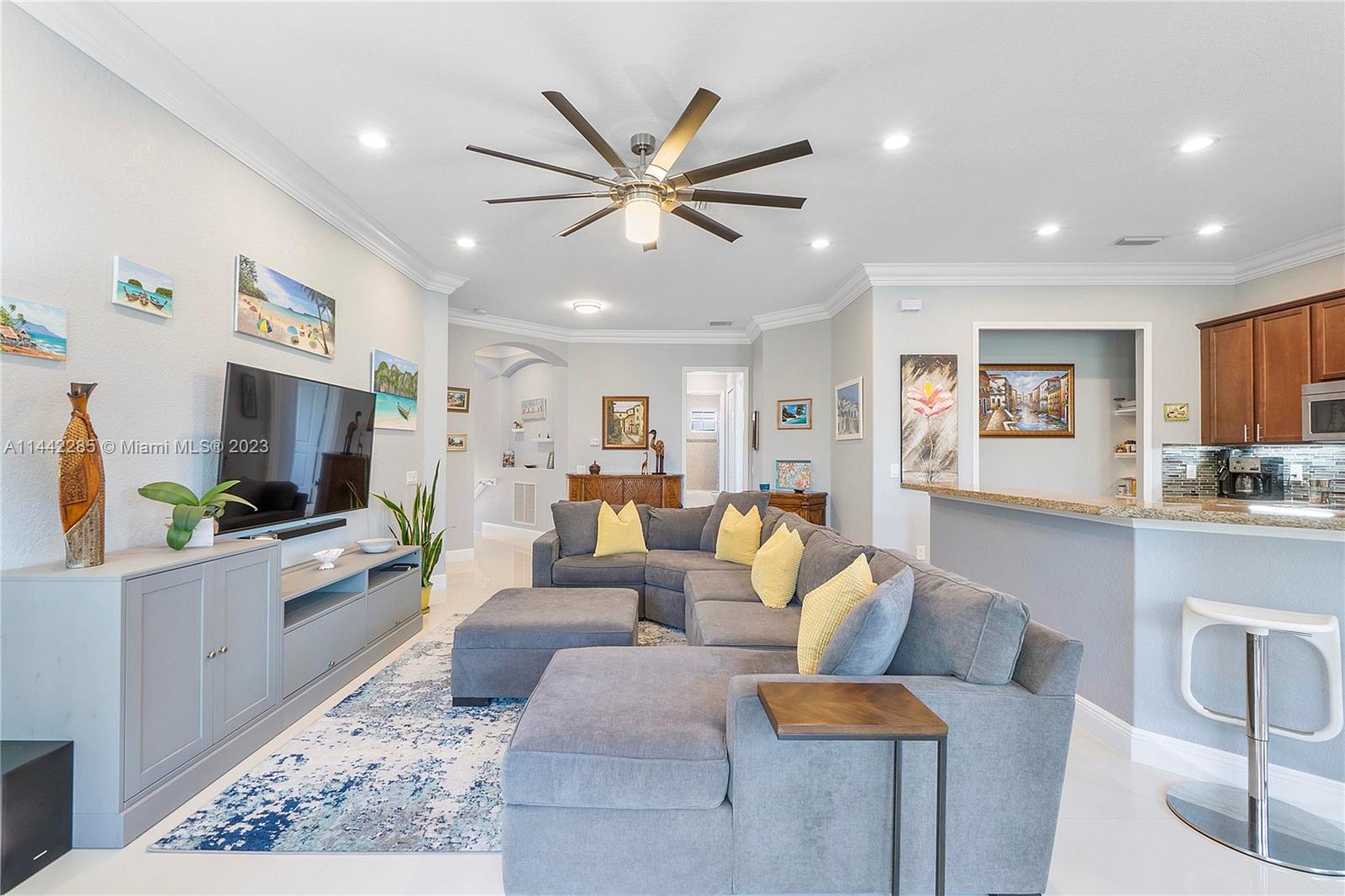 Heron Bay Parkland, FL 33076 - Photo 11 of 60 a living room with furniture a flat screen tv and kitchen view
