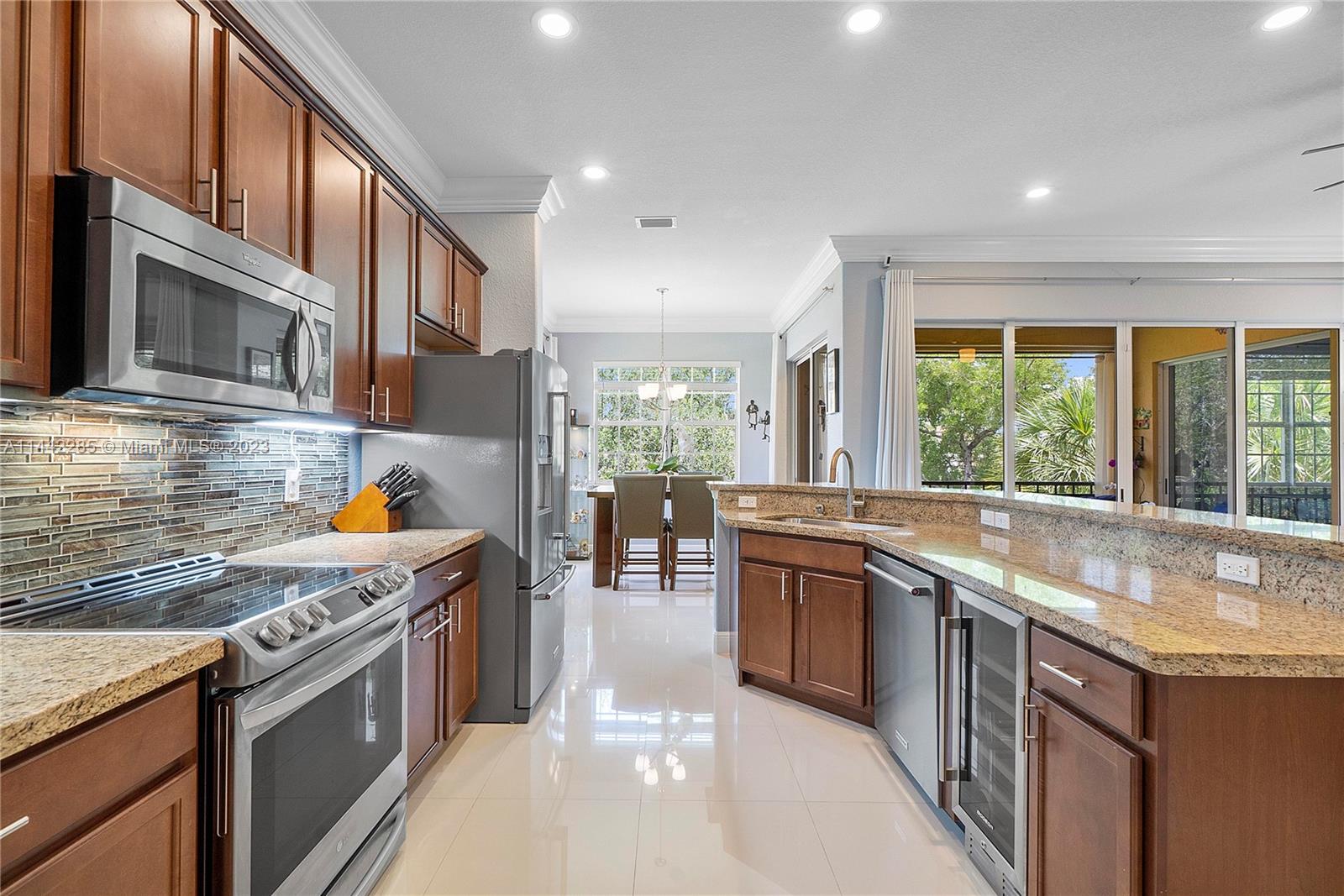 Heron Bay Parkland, FL 33076 - Photo 15 of 60 a kitchen with stainless steel appliances granite countertop sink stove and refrigerator