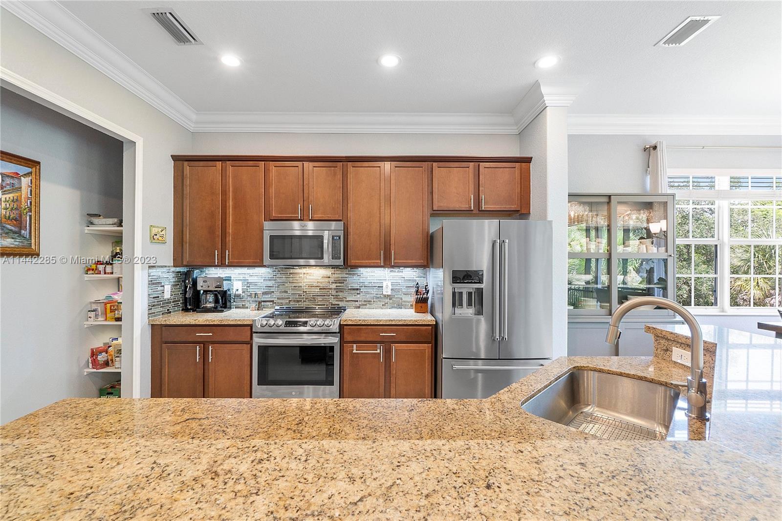 Heron Bay Parkland, FL 33076 - Photo 17 of 60 a kitchen with stainless steel appliances granite countertop a stove top oven a sink dishwasher a refrigerator and a cabinets with wooden floor