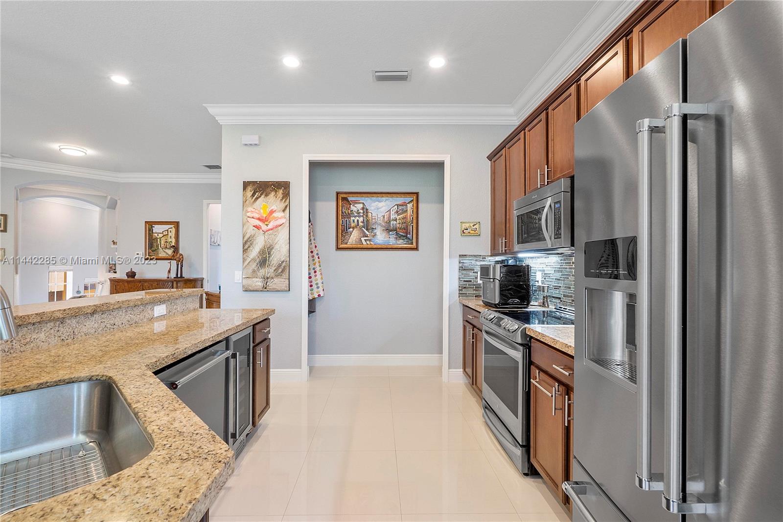 Heron Bay Parkland, FL 33076 - Photo 19 of 60 a kitchen with stainless steel appliances granite countertop a refrigerator a stove and a sink