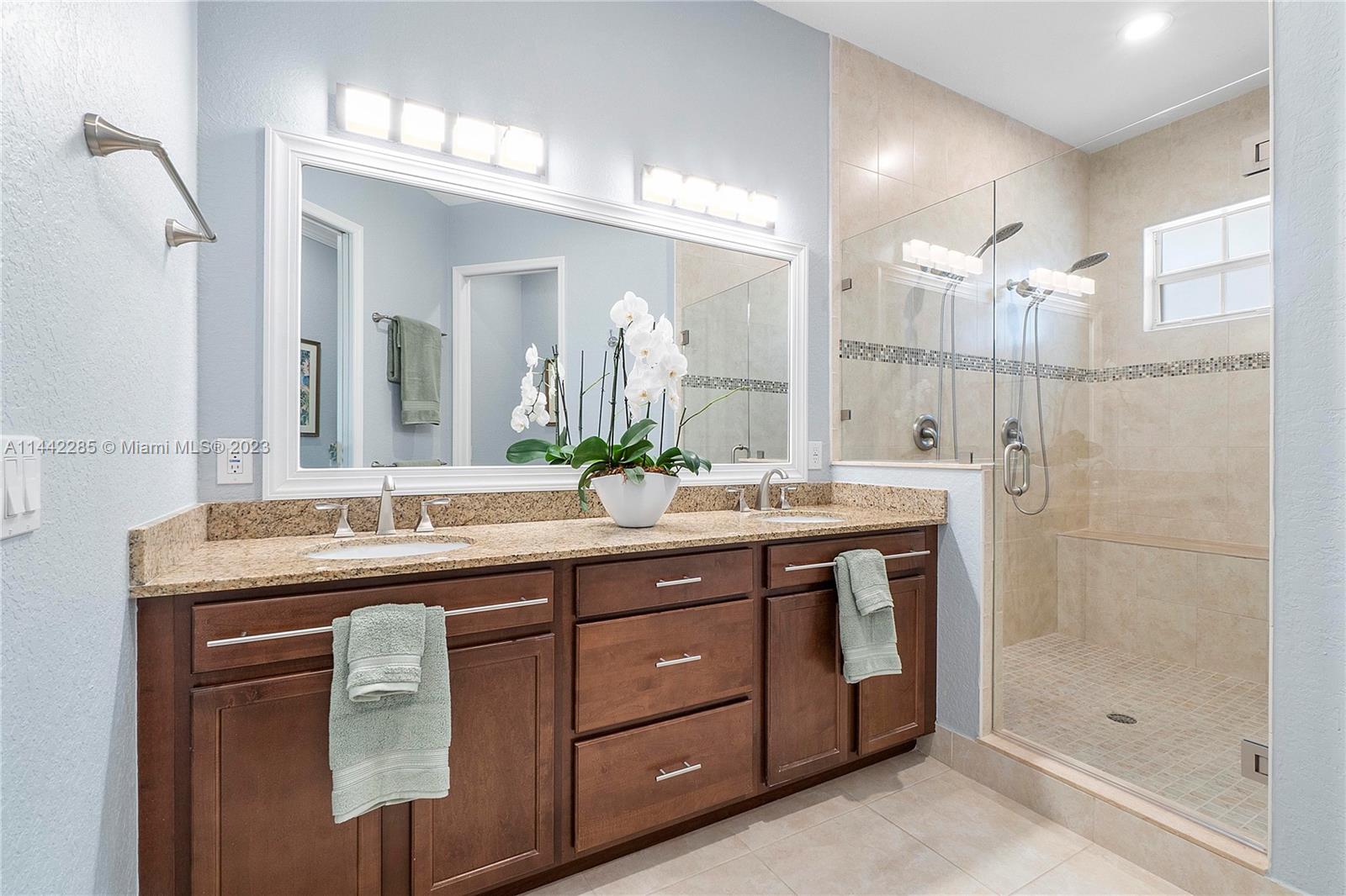 Heron Bay Parkland, FL 33076 - Photo 28 of 60 a bathroom with a granite countertop sink a large mirror and a shower