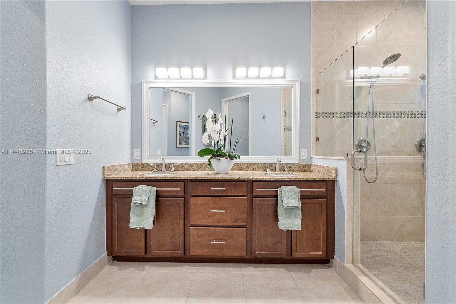 Heron Bay Parkland, FL 33076 - Photo 29 of 60 a bathroom with a granite countertop sink a mirror and a shower