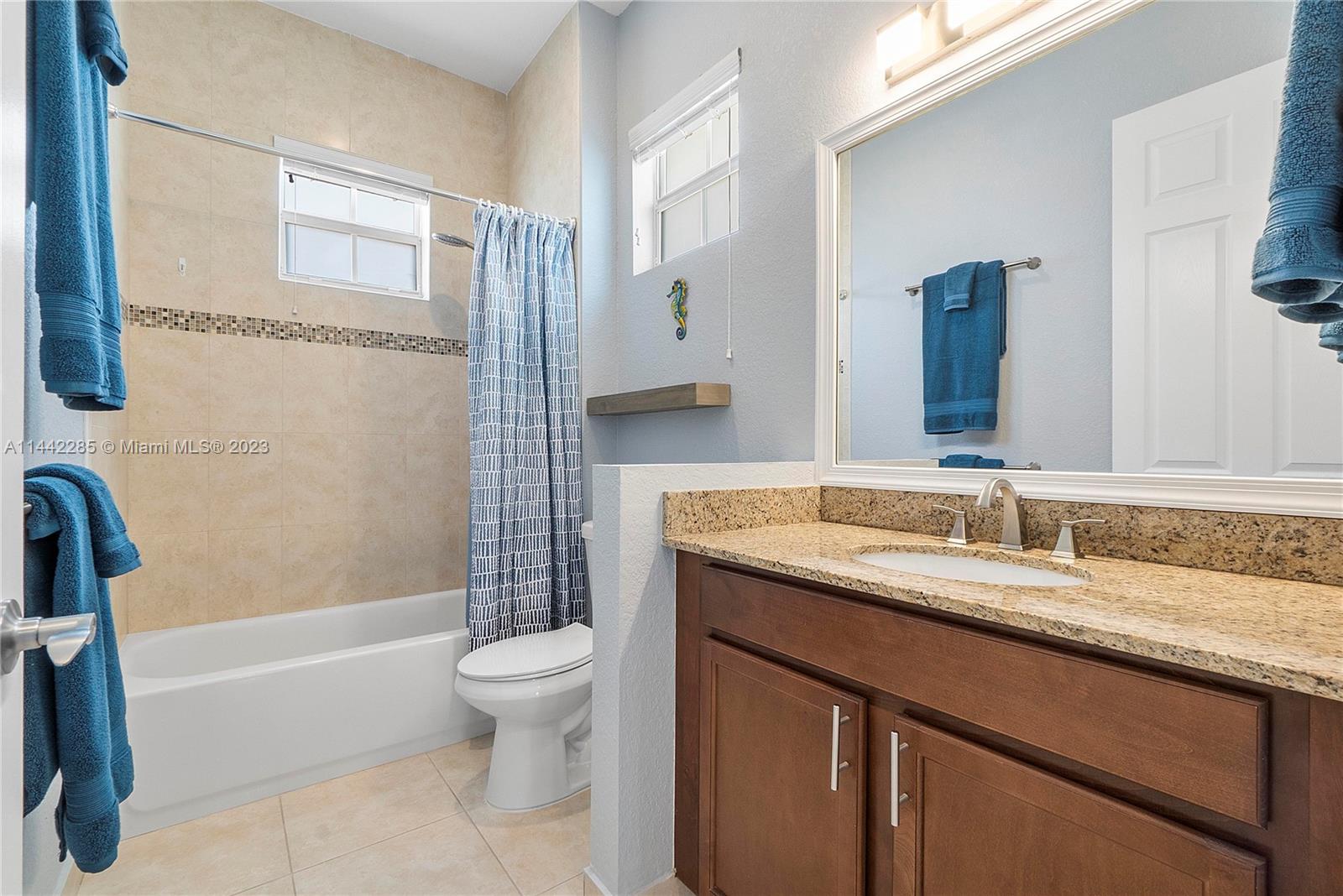 Heron Bay Parkland, FL 33076 - Photo 36 of 60 a bathroom with a granite countertop sink a toilet and a large mirror