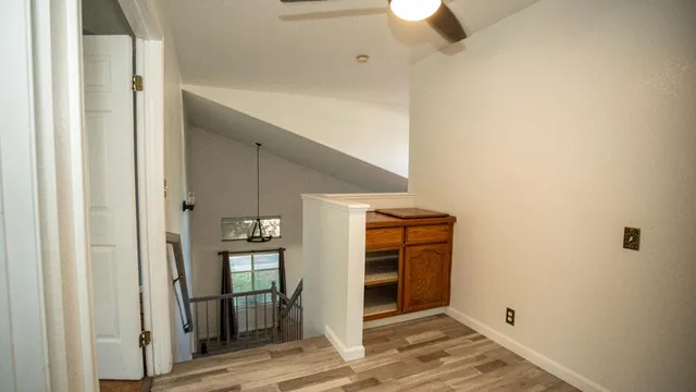 a view of a hallway with wooden floor and entryway