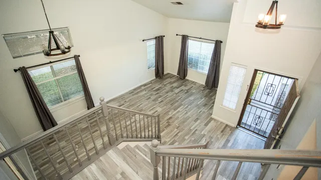 a view of a hallway with wooden floor and staircase