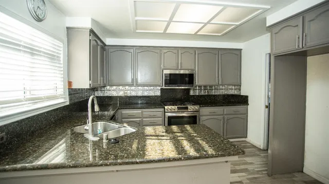 a spacious bedroom with a large window and potted plants