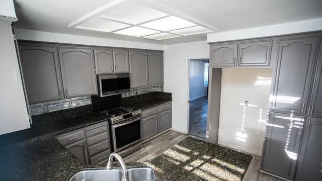 a kitchen with white cabinets and a stove top oven