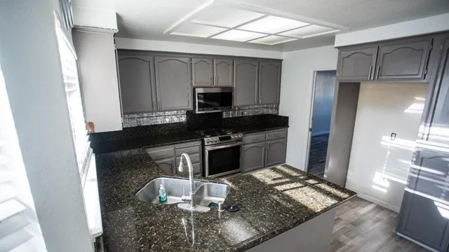 a kitchen with a refrigerator and a stove top oven