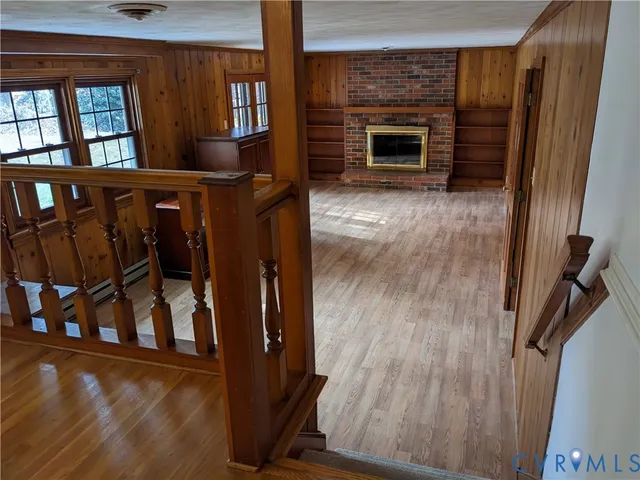 a view of an empty room with a fireplace and a window