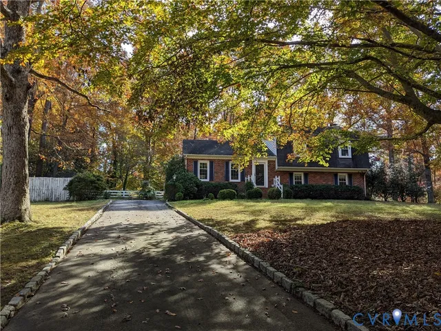 a view of a house with a yard and large tree