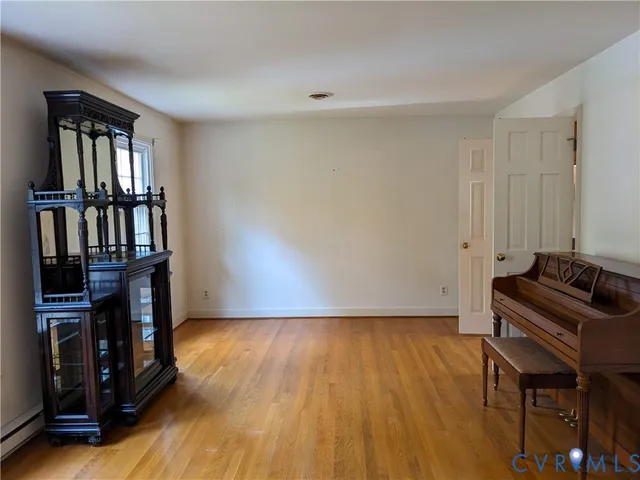 a view of a hallway with wooden floor and a living room