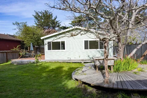 a view of a house with backyard and sitting area