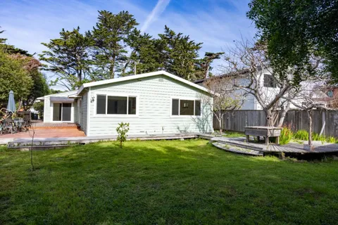 a front view of a house with a garden and swimming pool