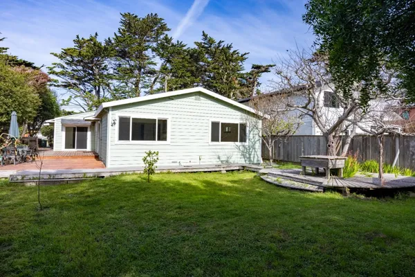 a front view of a house with a garden and swimming pool