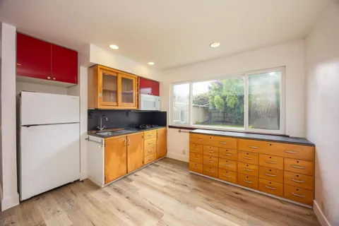 a kitchen with stainless steel appliances granite countertop a refrigerator a sink and dishwasher with wooden floor