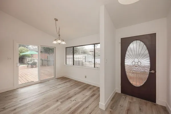 an empty room with wooden floor mirror and windows